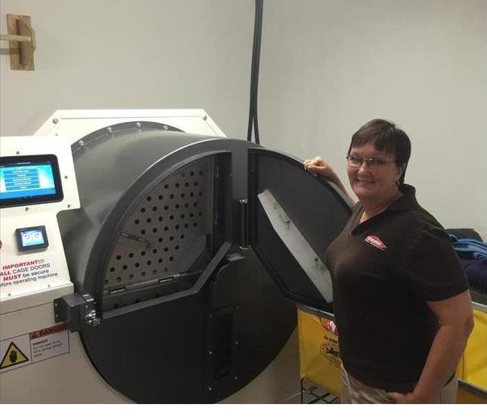 A woman smiling and standing next to a giant black and white ESPORTA machine 