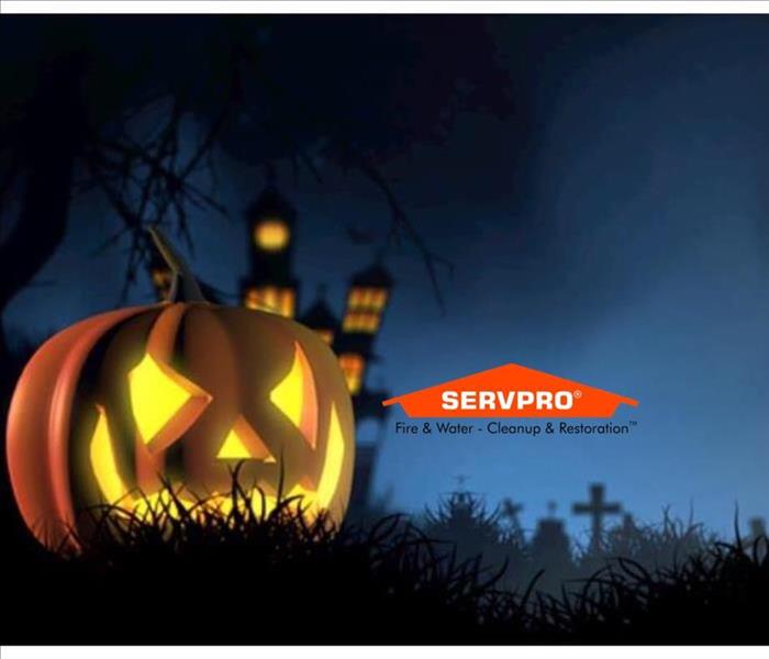 A pumpkin with a face carved out of it and a light inside with a dark blue background and SERVPRO logo next to it 