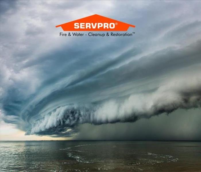 A view of the ocean with a sky full of white and green clouds meaning there's a storm coming and the SERVPRO logo at the top