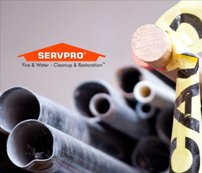 A close up of grey pipes and the SERVPRO logo at the top